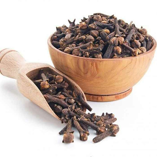 a bowl of cloves and a wooden scoop laving